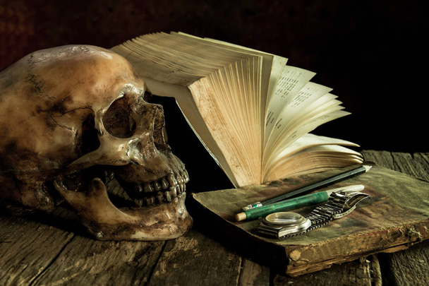 Naturaleza muerta con un cráneo y libro sobre madera
 - Foto, imagen