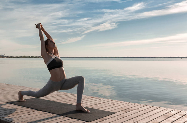 Sports lady standing at the beach make yoga exercises. - Фото, зображення