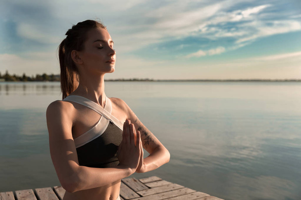 Young sports lady at the beach make meditation exercises. - Fotografie, Obrázek
