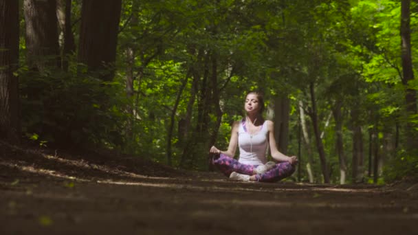 Młoda kobieta medytacja w parku - Materiał filmowy, wideo