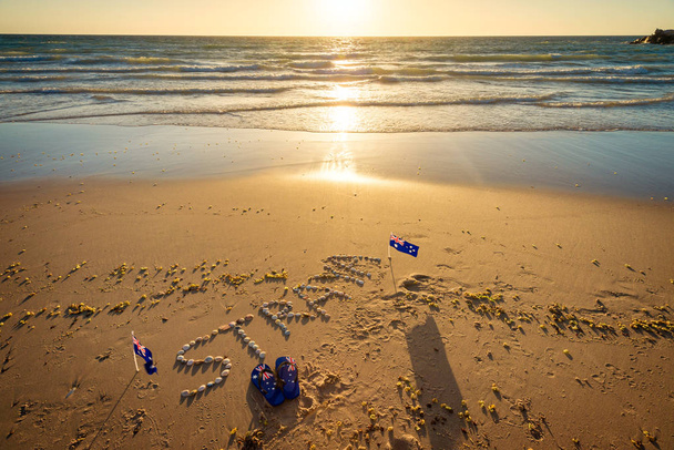 Straya tekst, vlag en slipper op strand - Foto, afbeelding