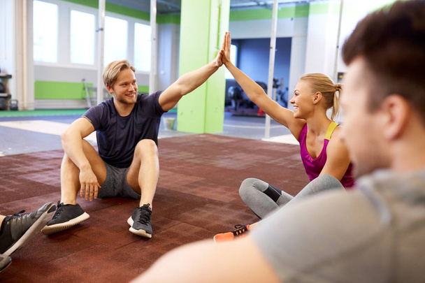 group of happy friends making high five in gym - Photo, Image