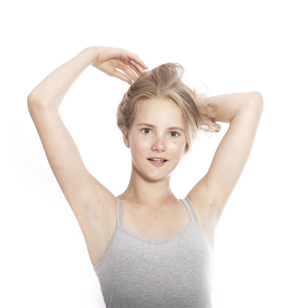 young teen girl holds blond hair up against white background - Photo, Image
