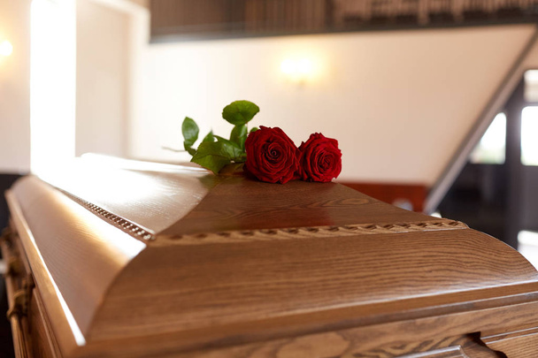 red rose flowers on wooden coffin in church - Foto, Imagen