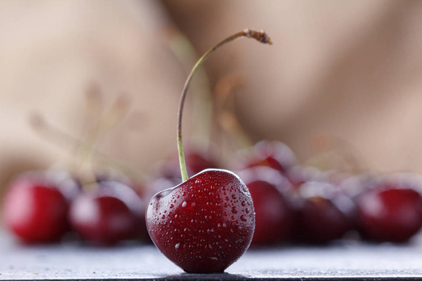 Bright juicy cherry berries on a baggy background. - Photo, image