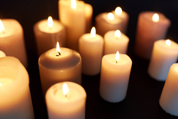 candles burning in darkness over black background - Foto, Imagem