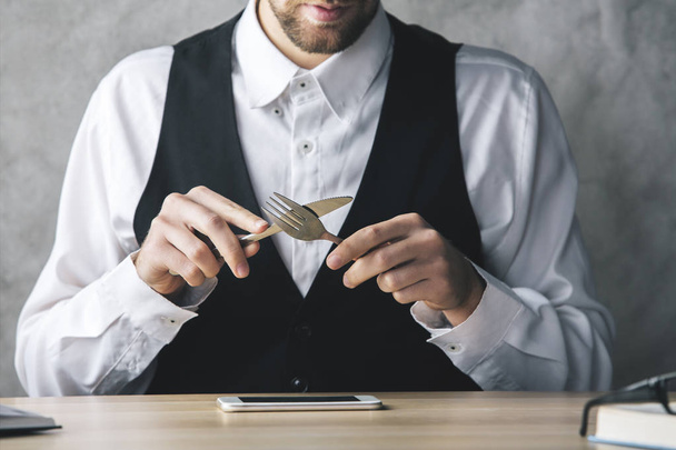 Сумасшедший бизнесмен ест смартфон
 - Фото, изображение