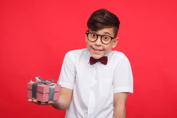 Улыбающийся мальчик позирует с подарочной коробкой
 - Фото, изображение