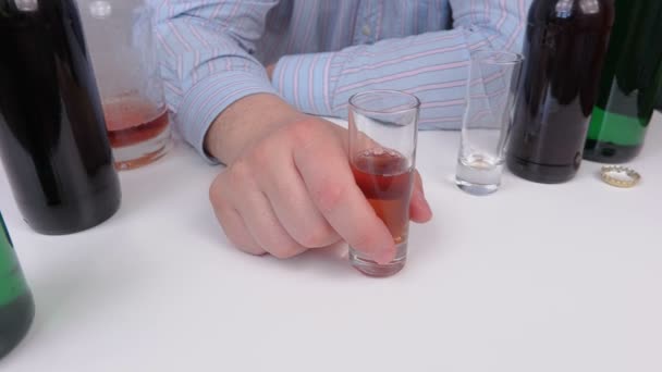 Mies juo alkoholia pöydän lähellä
 - Materiaali, video