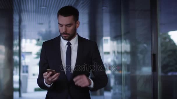 Businessman Walking on Streets of Business District and using Mobile Phone - Video