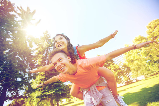 gelukkige tiener paar plezier op zomer park - Foto, afbeelding