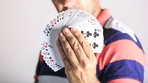 Homem mostrando carta de baralho em sua mão
 - Foto, Imagem