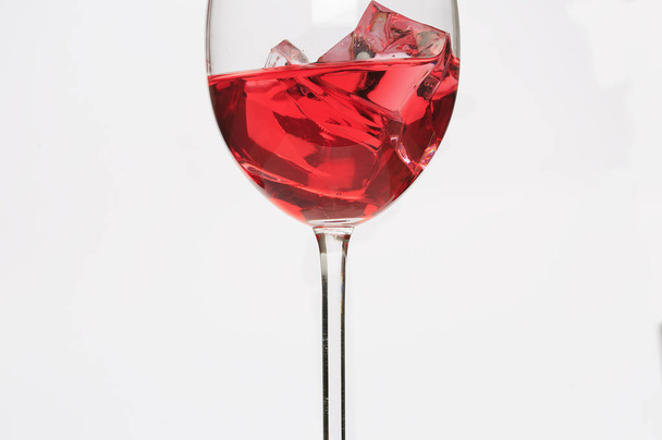 Стеклянная чашка с красной жидкостью и льдом
 - Фото, изображение
