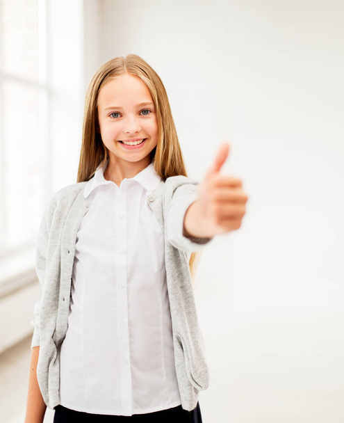 happy smiling student girl showing thumbs up - Фото, зображення