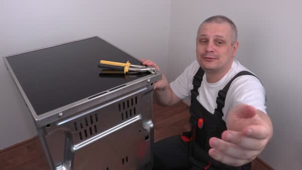 Eletricista começar a fixar tampa traseira do fogão elétrico
 - Filmagem, Vídeo