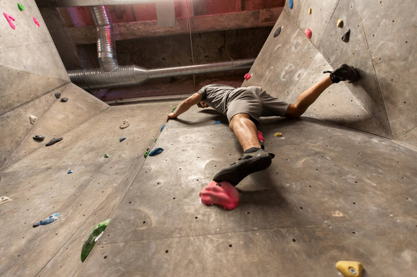 young man exercising at indoor climbing gym - Фото, изображение