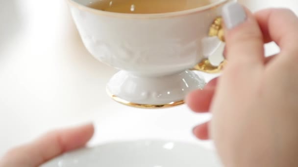Manos femeninas sosteniendo una taza de té caliente por la mañana. Buenos días Tea or Have a happy day message concept
 - Imágenes, Vídeo