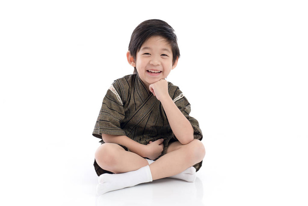 heureux asiatique garçon dans kimono assis sur blanc fond isolé
 - Photo, image