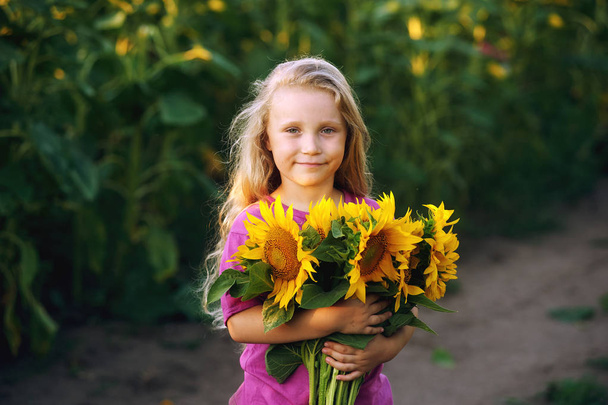 Portret dziewczynki z bukietem słoneczników . - Zdjęcie, obraz