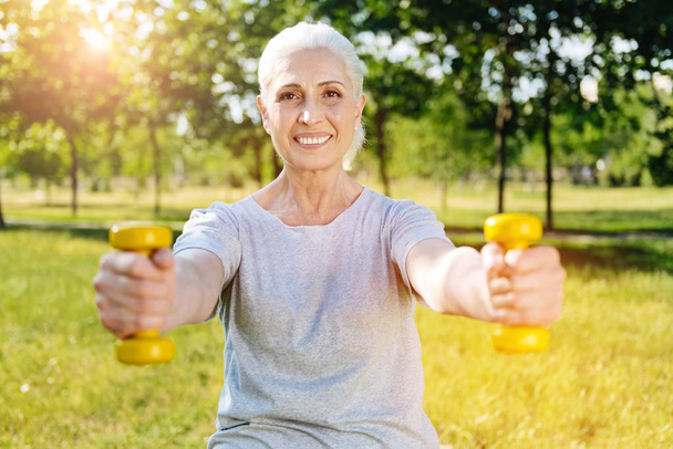 aged woman practicing with dumbbells - Foto, Bild