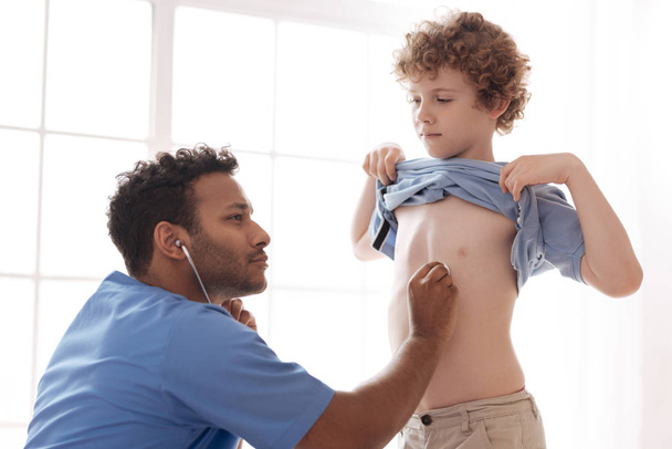 Ernstige internationale arts controleren heartbeat - Foto, afbeelding