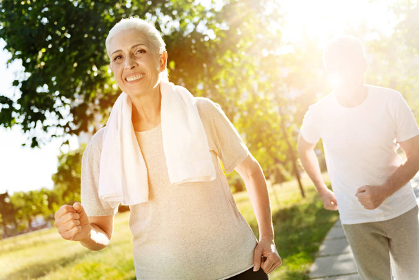 Positive senior woman jogging with her husband - Foto, immagini