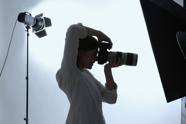 Female photographer working in studio - Фото, изображение