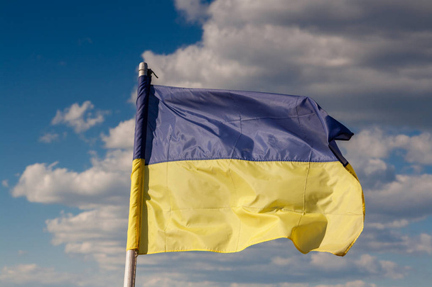Ukrainan lippu taustaa vasten joen ja taivaan
 - Valokuva, kuva
