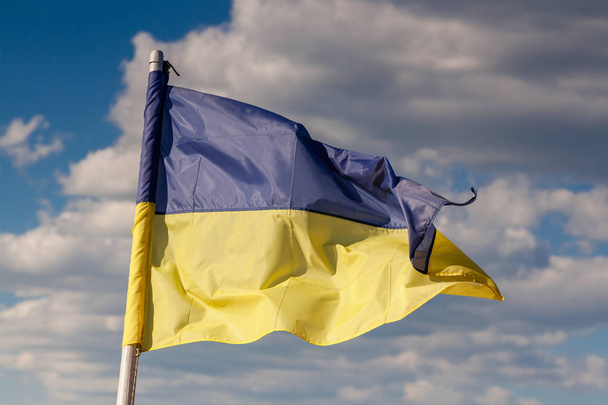 Ukrainian flag against the background of the river and sky - Foto, Imagen