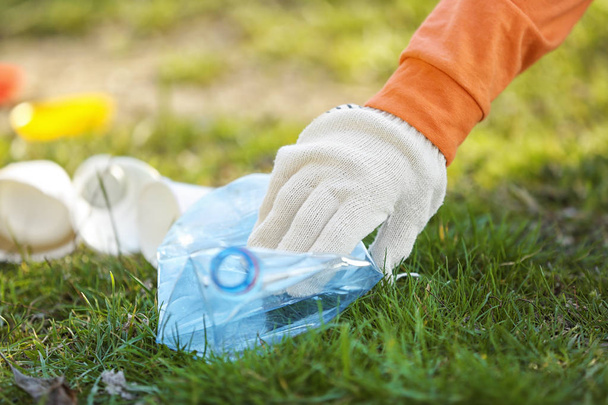 Volunteer picking up litter from grass - Foto, Imagen