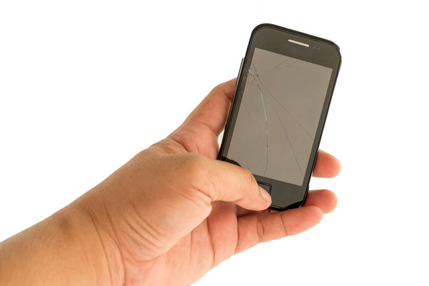 Hand hält ein Handy mit kaputtem Bildschirm. - Foto, Bild