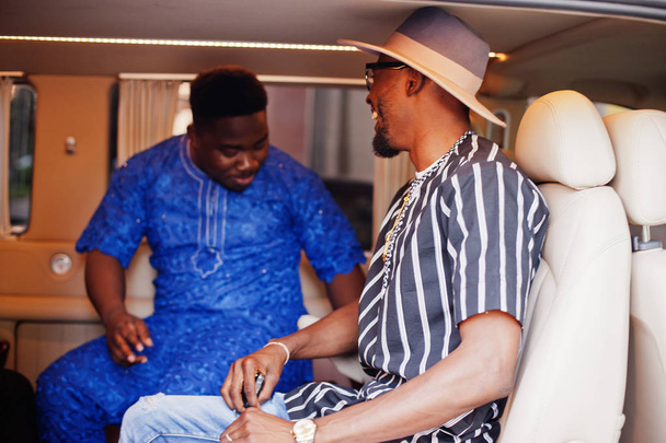 Black men wearing cool traditional clothes in the minivan. - Fotó, kép