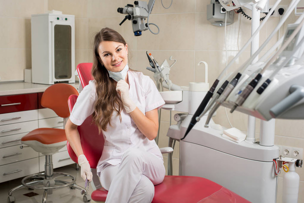 Attractive female doctor with microscope in the modern dentist office - Photo, Image