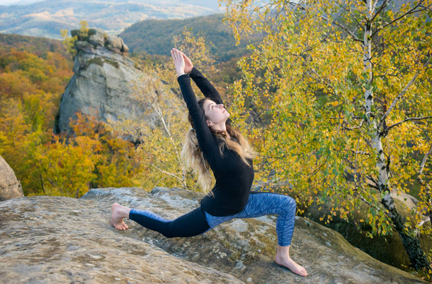 Donna in forma sportiva sta praticando yoga sulla cima della montagna
 - Foto, immagini