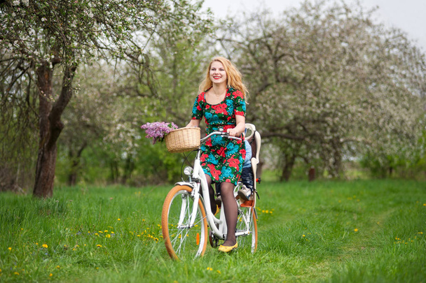 Rubia mujer montando bicicleta de ciudad con bebé en silla de bicicleta
 - Foto, Imagen