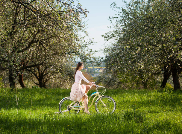 Mooie wielrenster met retro fiets in de lentetuin - Foto, afbeelding