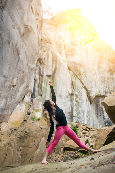 Sportieve fit vrouw is het beoefenen van yoga op de Kei in de natuur - Foto, afbeelding