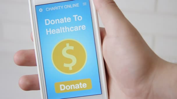 Homem fazendo uma doação on-line para cuidados de saúde usando aplicativo de caridade no smartphone
 - Filmagem, Vídeo