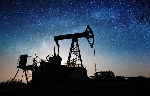 Нефтяной насос на нефтяном месторождении ночью
 - Фото, изображение