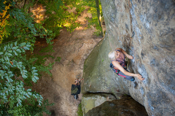Donna arrampicatrice sta arrampicando su una parete rocciosa
 - Foto, immagini