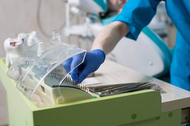 Крупным планом врач берет зубную щетку в кабинете стоматолога
 - Фото, изображение