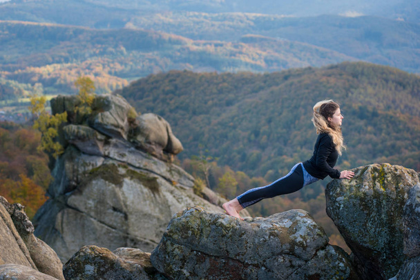 Sportovní fit žena cvičí jógu na vrcholu hory - Fotografie, Obrázek
