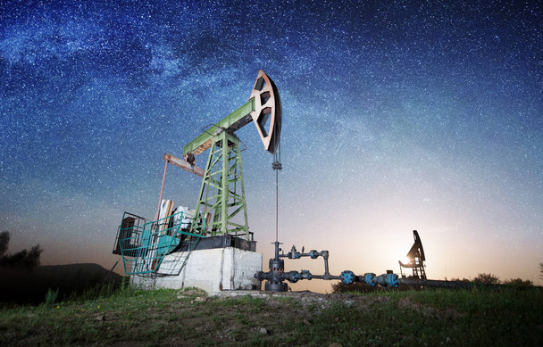 Pompe à huile sur le champ de pétrole dans la nuit
 - Photo, image
