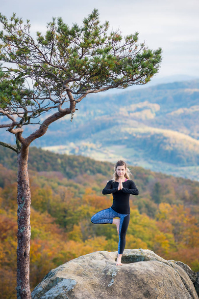 Спортивний туалет жінка практикує йогу на вершині гори
 - Фото, зображення