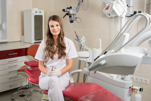 Attractive female doctor with microscope in the modern dentist office - Zdjęcie, obraz