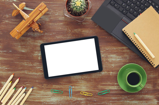 Вид зверху офісного робочого столу з лептопом, планшетом, блокнотом і чашкою кави
 - Фото, зображення