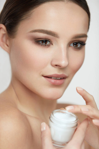 Face Beauty Care. Woman With Natural Makeup Holding Cream - Foto, Imagem