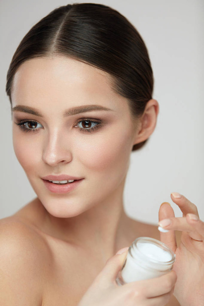 Face Beauty Care. Woman With Natural Makeup Holding Cream - Photo, Image