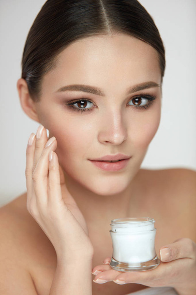 Face Skin Care. Beautiful Girl Putting Cream On Soft Smooth Skin - Foto, Imagem