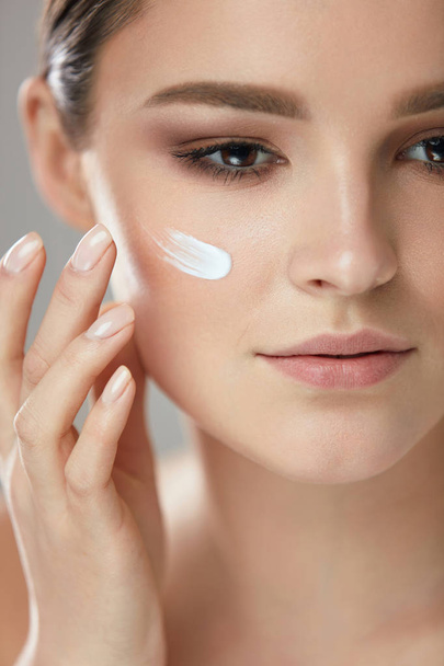Facial Care. Closup Beautiful Woman Putting Skin Cream On Face - Фото, зображення
